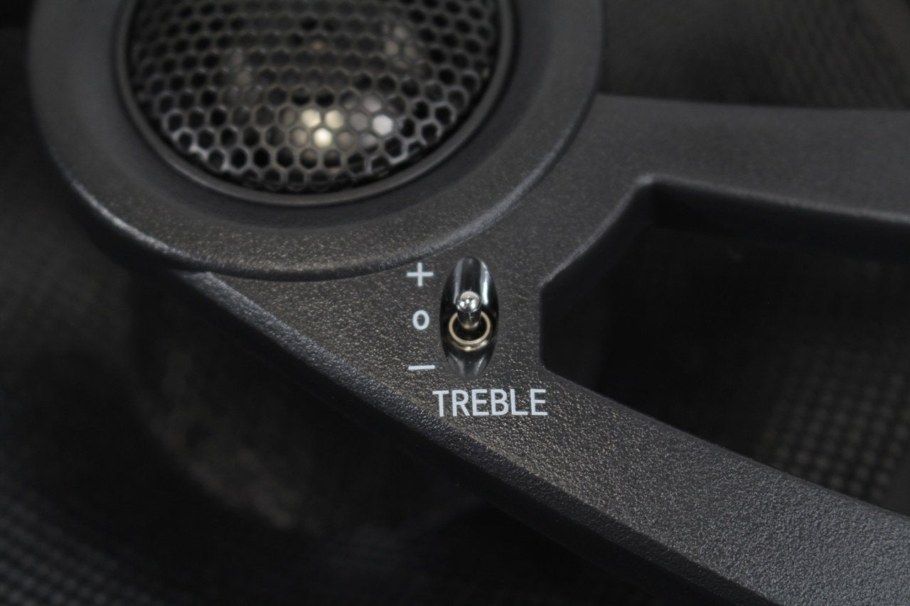 Treble control knob on a speaker with 'TREBLE' label
